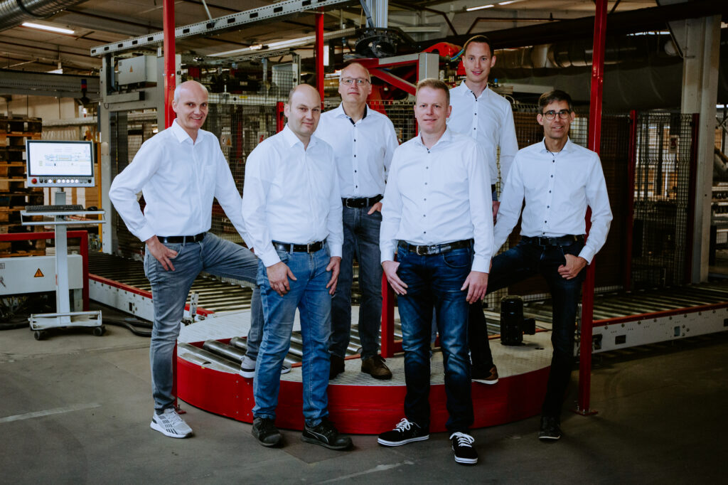 Das Team vor einer Produktionsanlage